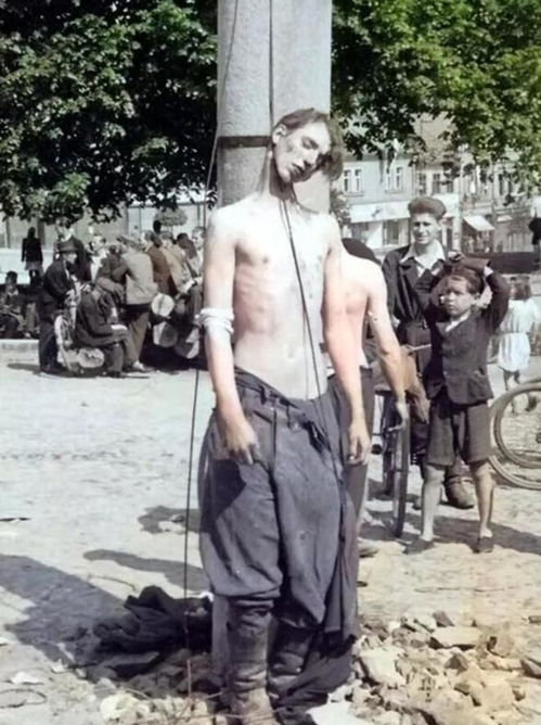 1945年,一名德军士兵被绞死在立柱旁,周围围观的不多且表情平淡